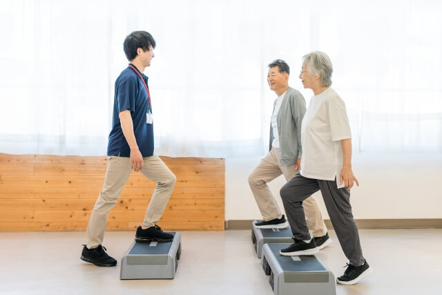 トレーナーとトレーニングをするシニアの夫婦